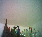 Sammlung verschiedenförmiger Flaschen unter der Decke in der Zimmerecke