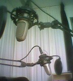 Zwei Studiomikrofone vor weißem Vorhang, über- und hintereinander
